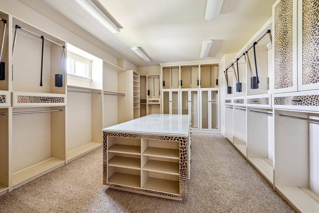 This large walk-in closet features built-in shelving plus pull downs to maximize your space!