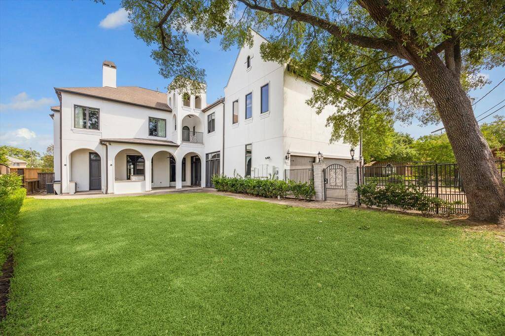 Another view of the yard with the pedestrian gate to the right, along with the 3-car garage and additional gated parking.