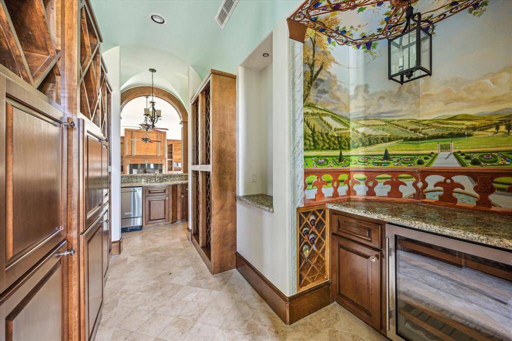 The wine room includes ample wine storage, a beverage fridge, separate ice maker, and sink. It looks into the family room for easy access!