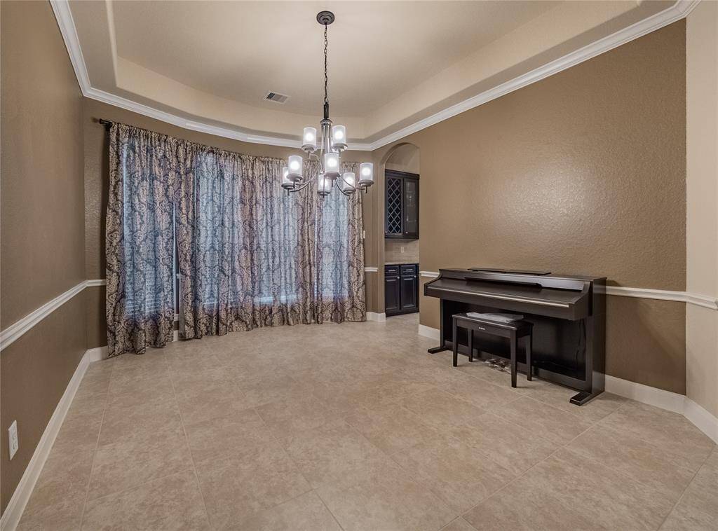 formal dining room has floor to ceiling windows beautiful chandelier and tile flooring , tier ceiling