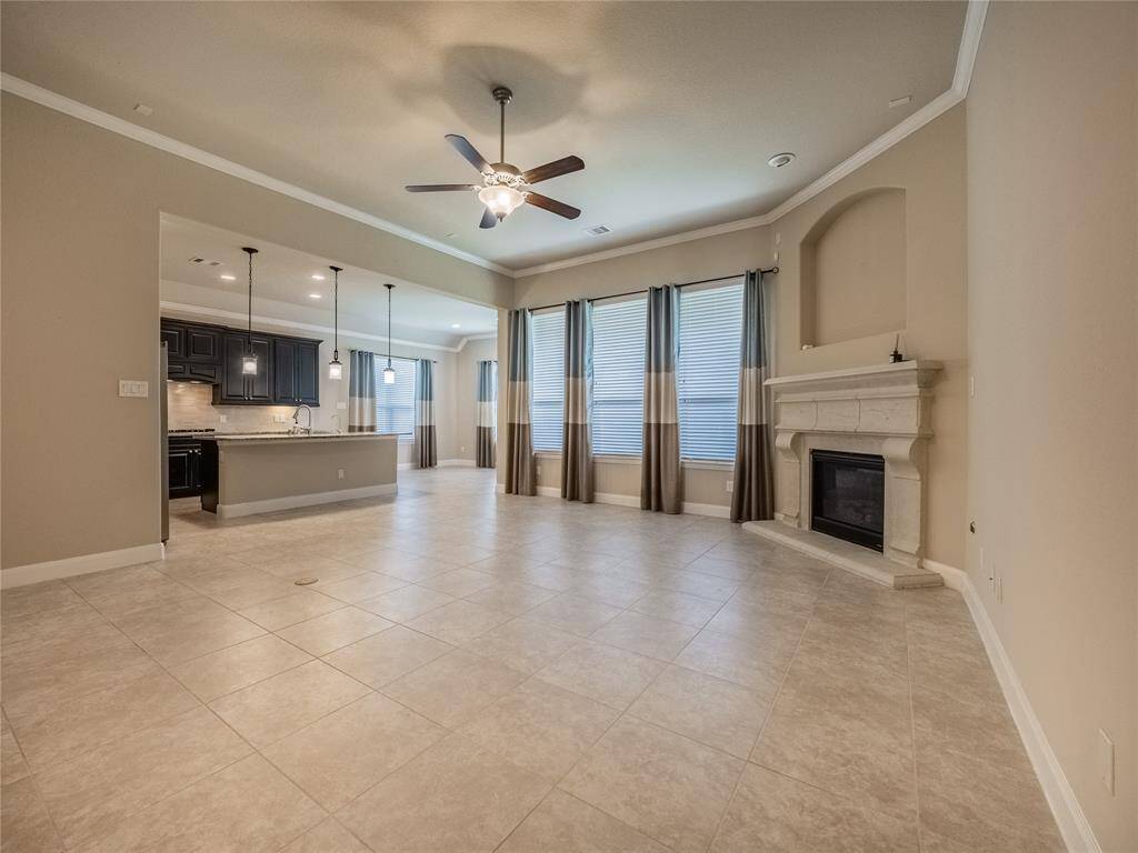 this is the family room open to the kitchen very spacious with a corner fireplace, floor to ceiling windows to offer natural lighting , also has the tier ceiling with crown molding
