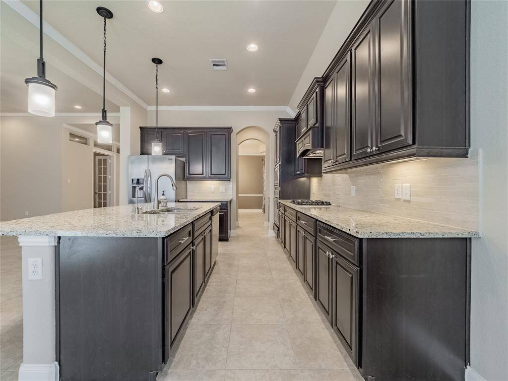 the kitchen is any chefs dream, you have the extended counter top which is great for entertaining, granite counter tops and the gorgeous wooden cabinets with silver hardware  and great pendulum lighting over the counter