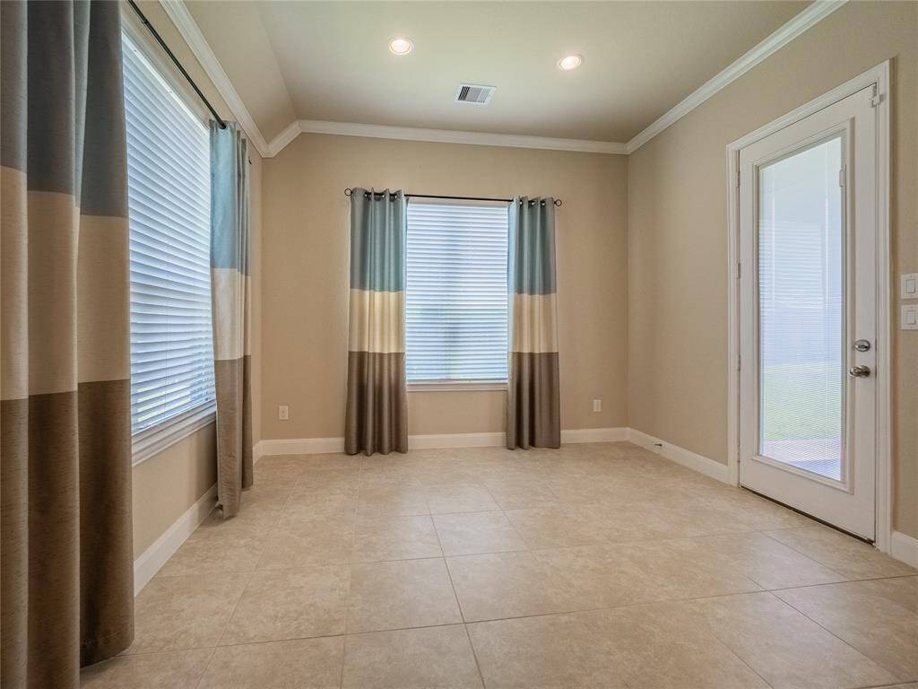 another view of the breakfast nook showing the back door leading to the covered patio and large backyard