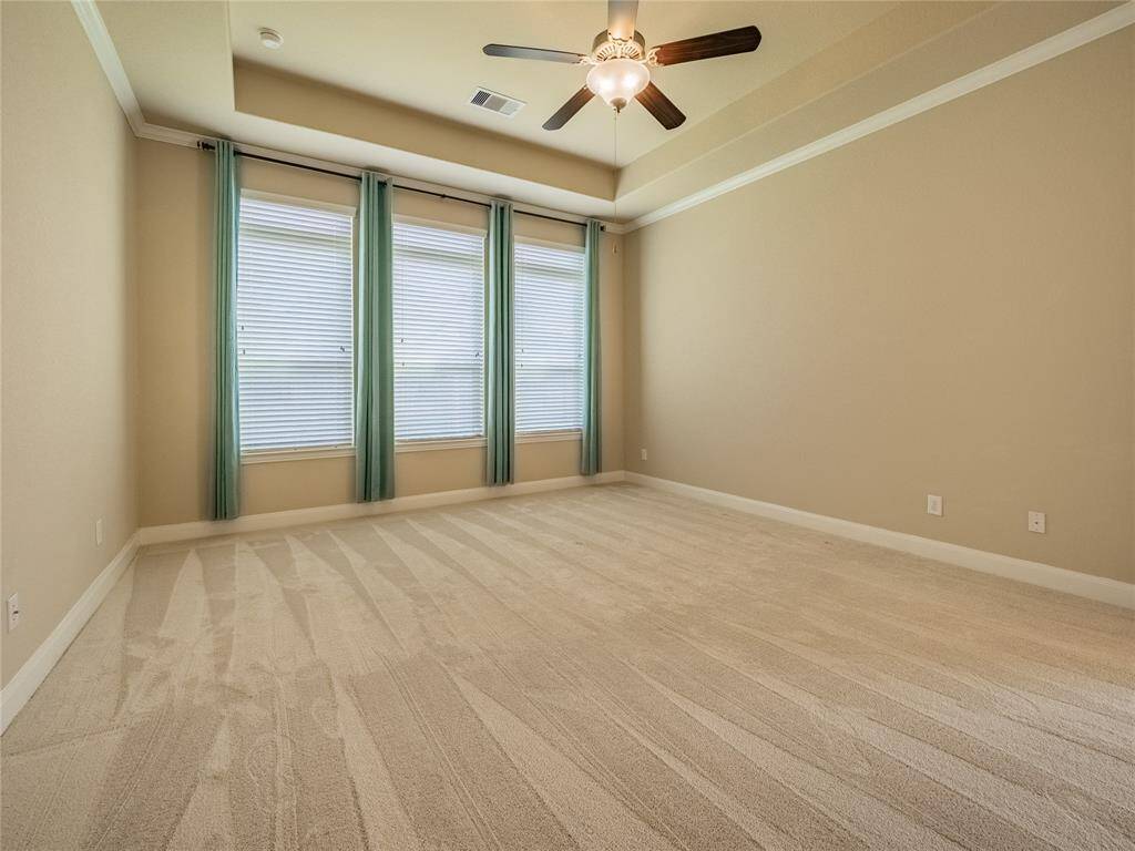 primary suite with oversized windows which offer natural light also  over looking the back yard , trey ceilings , recessed lighting and ceiling fan