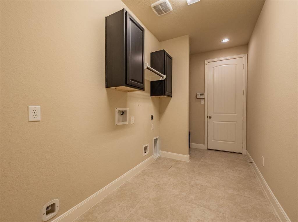 laundry room has cabinets, hanging rack and room for a fridge if you want
