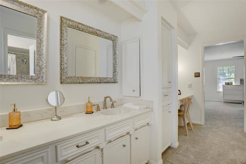 The primary bathroom offers double sinks, vanity area, linen and medicine storage, and a spacious walk-in closet.