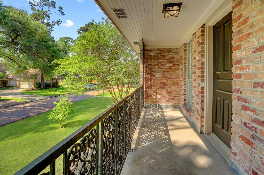 Between the primary and secondary bedrooms is a long balcony overlooking the front yard and Coral Gables Dr.