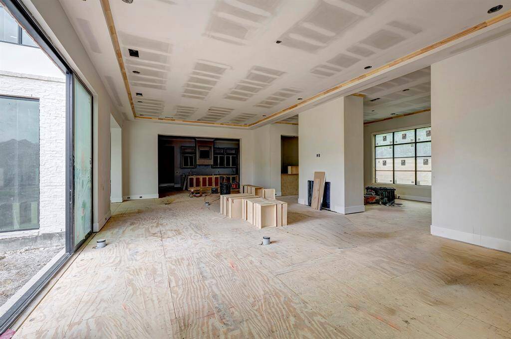 Spacious living room with fireplace has access to the pool area through the large glass sliding doors. Stage of construction as of April 3, 2025.