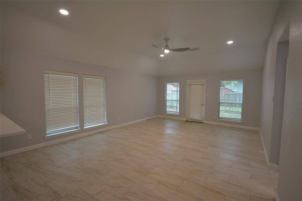 Nice open living room with vaulted ceilings and door to the backyard.