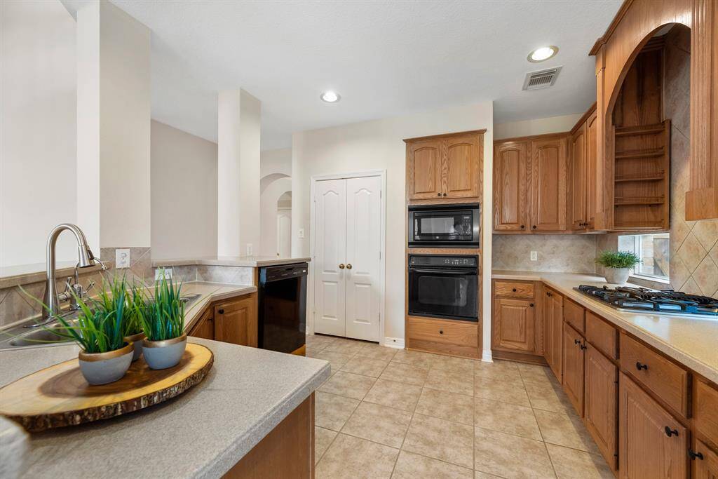 Neutral kitchen with a raised dishwasher for easy loading. Built in spice rack on both sides of the cooktop for convenience.