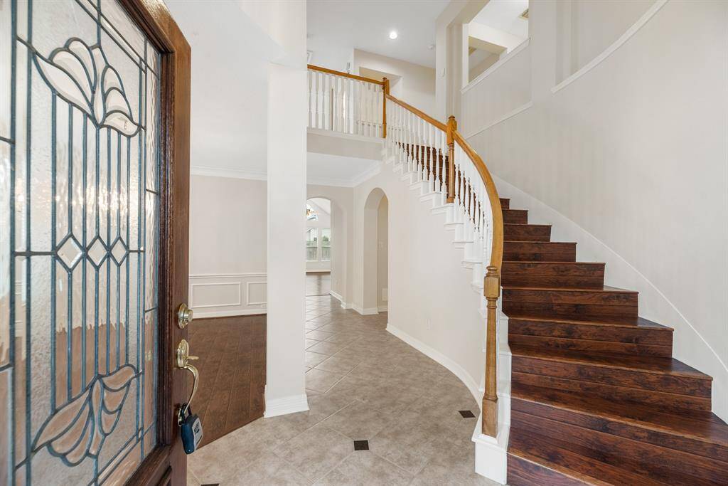 Dramatic wooden staircase welcomes you in.