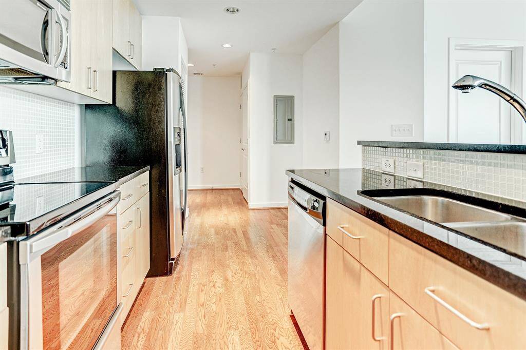 The kitchen has mosaic tile backsplash, undermount sink, and contemporary cabinets. Refrigerator is included. Adjacent to the kitchen is the 6x9 dining area.