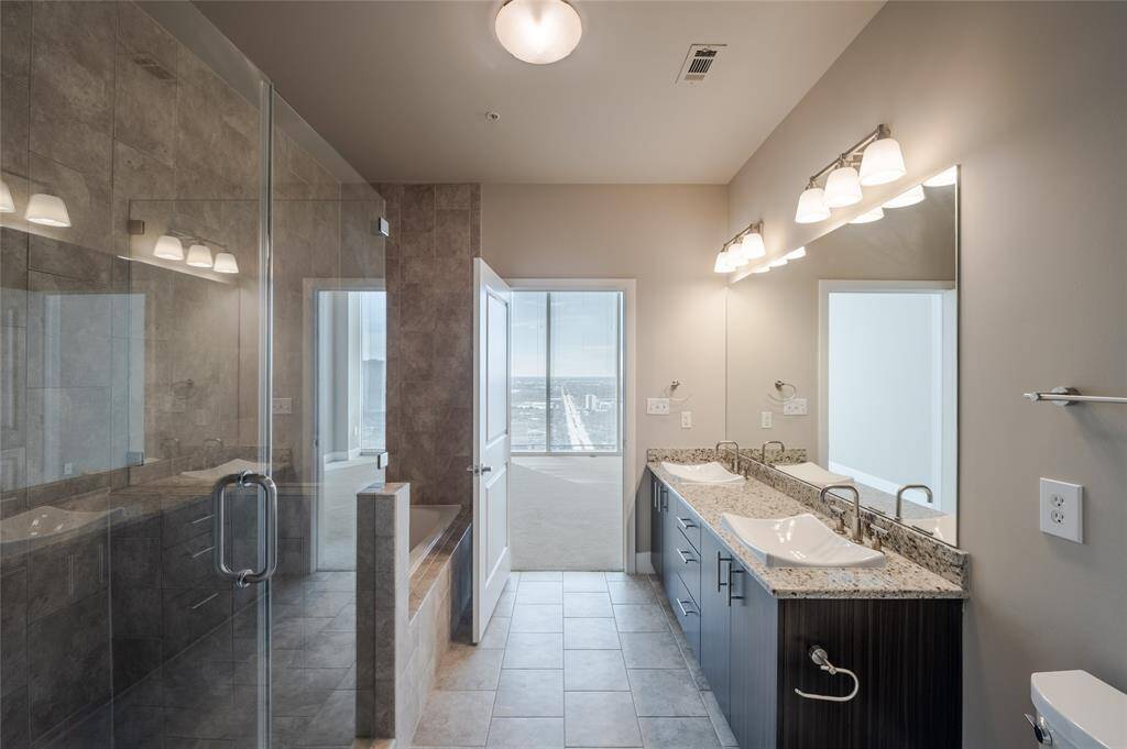 Designed to feel like a private spa retreat, the space features oversized glass walk in shower and relaxing soaking tub.