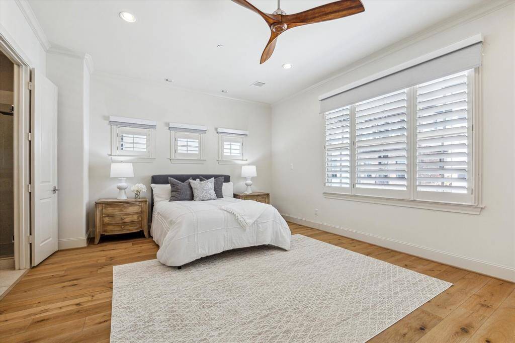Primary Bedroom (14' x 20') with high ceilings, plantation shutters, remote blinds, and white oak floors.