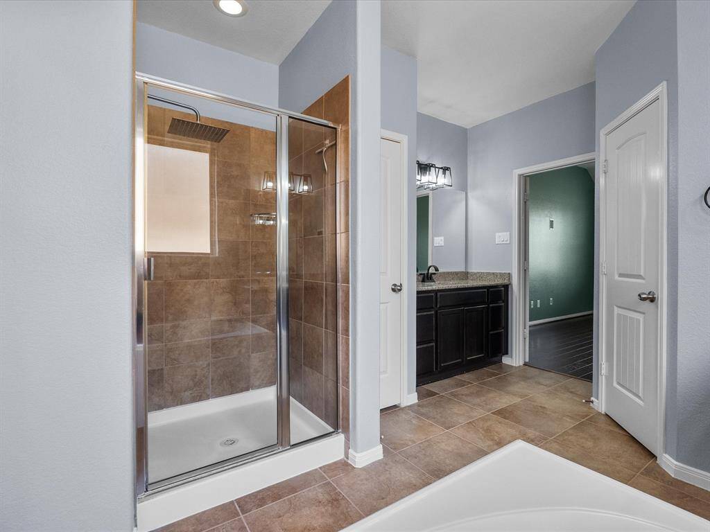 Primary en-suite bath features dual vanities, walk-in shower, soaking tub and a walk-in closet