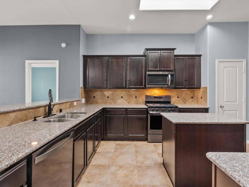 Chef's eat-in island kitchen features lengthy granite countertops, 42" cabinets with crown molding, stainless steel appliances and a breakfast bar. Fridge stays with the home.