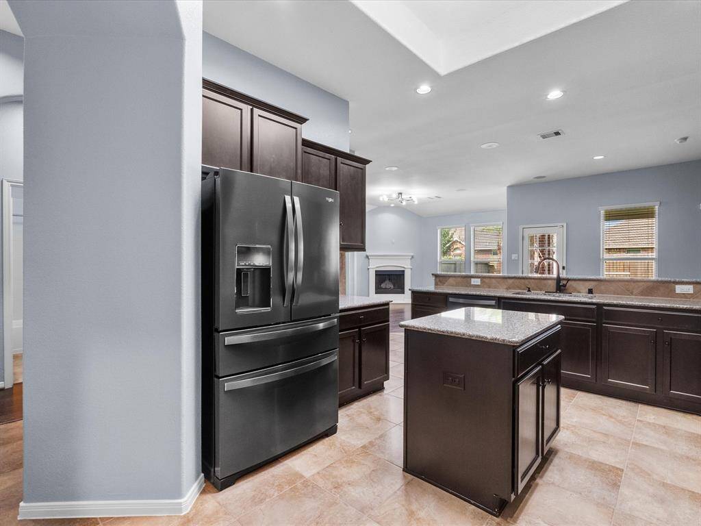 Chef's eat-in island kitchen features lengthy granite countertops, 42" cabinets with crown molding, stainless steel appliances and a breakfast bar. Fridge stays with the home.