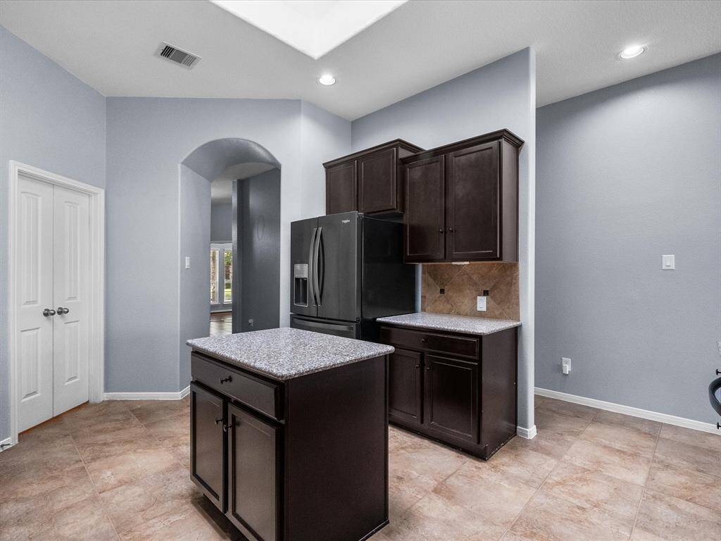Chef's eat-in island kitchen features lengthy granite countertops, 42" cabinets with crown molding, stainless steel appliances and a breakfast bar. Fridge stays with the home.