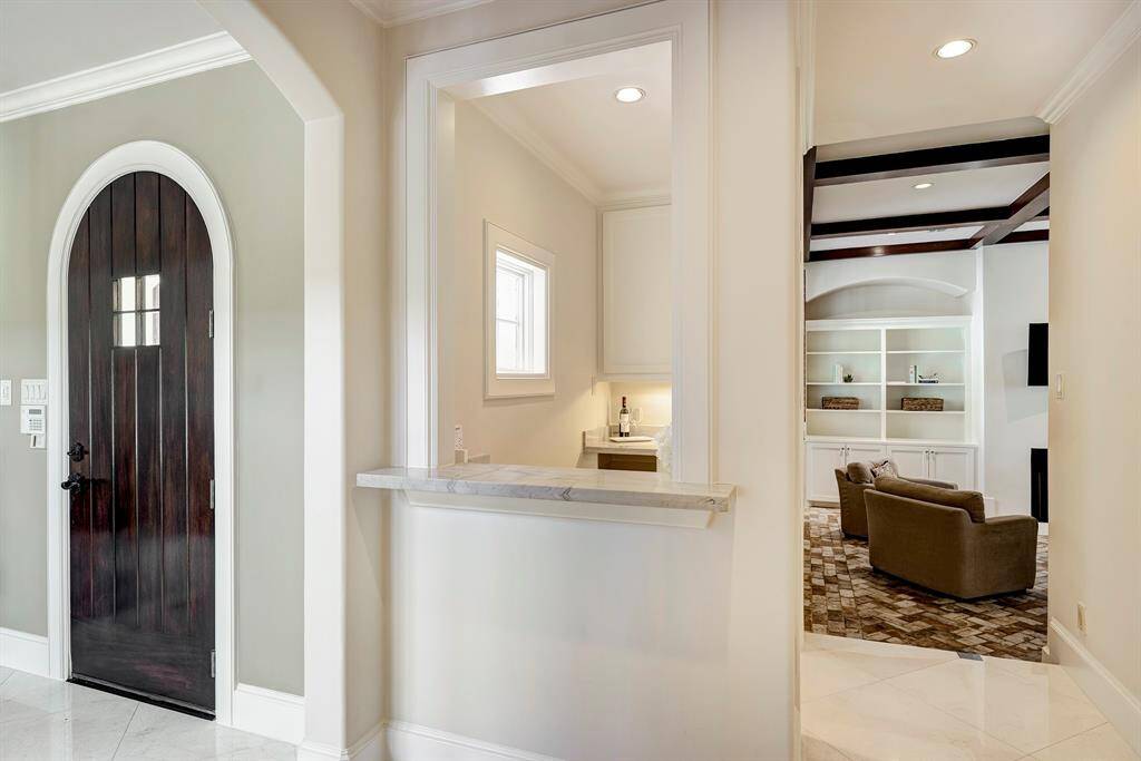 Wet bar to the right of the front door and the den in the back