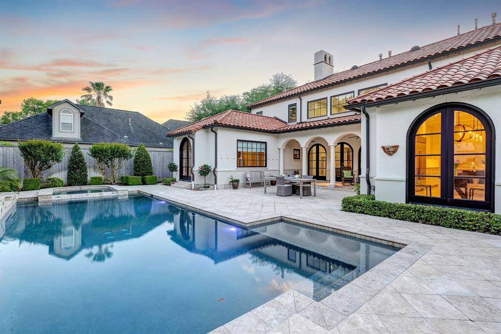 Shallow splash area on one end of the pool with spa on the other; just out of frame on the right is a half-bath accessible from the patio for guests