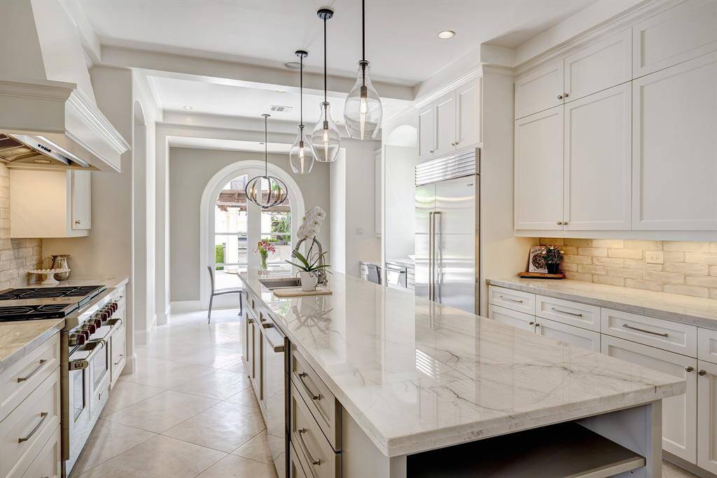 Serene and beautifully remodeled chef's kitchen w/ quartzite countertops, counter seating, Wolf 6 burner range, Sub Zero fridge and Thermador warming drawer