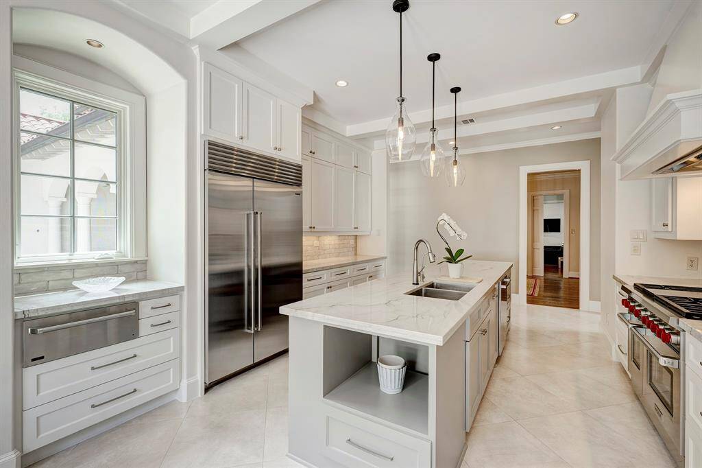 Serene and beautifully remodeled chef's kitchen w/ quartzite countertops, counter seating, Wolf 6 burner range, Sub Zero fridge and Thermador warming drawer