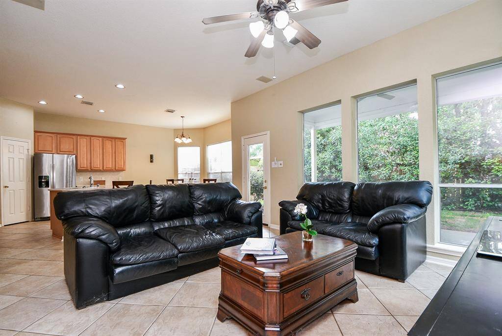 Walls of windows naturally light your huge living/family area, shared by the kitchen, beyond.