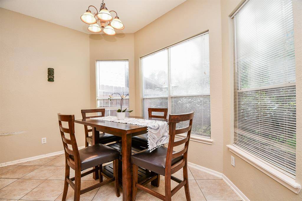 A huge bay window treatment bathes this spacious breakfast nook in pure natural light.