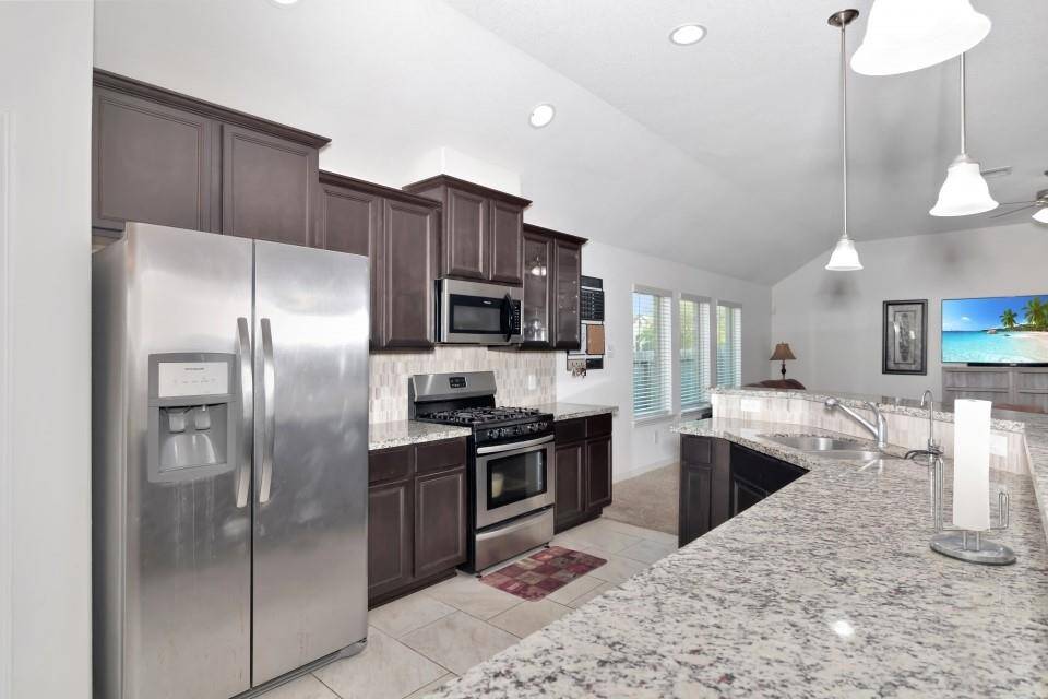 The spacious kitchen features stainless steel appliance and granite counter tops.