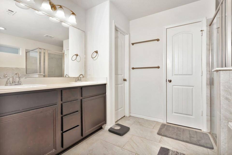 Primary on suite bathroom features dual sink, walk in shower, separate tub, private water closet and large walk in closet with access to the utility room.