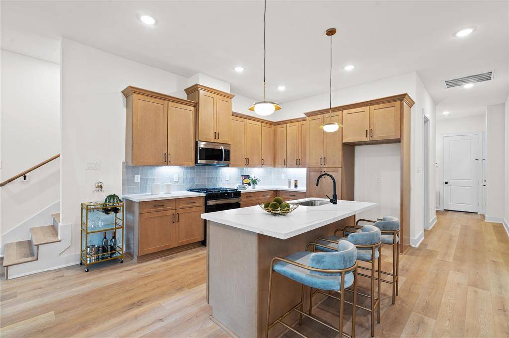 Kitchen features white quartz countertops, modern shaker cabinets, and stainless steel appliances. *Photos from a previous home by the same developer, selections and floor plans may vary*