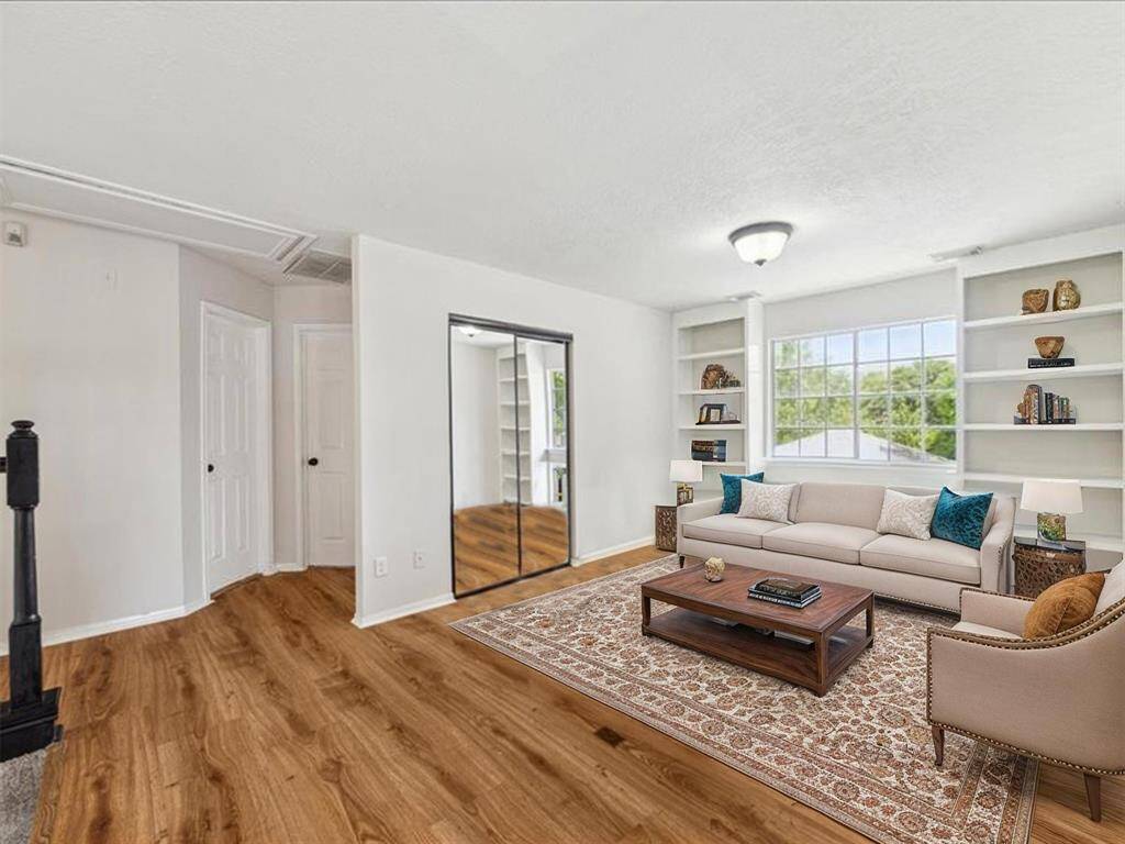 SPACIOUS GAME ROOM WITH BUILT-IN SHELVING AND A LARGE PICTURE WINDOW THAT FLOODS THE SPACE WITH NATURAL LIGHT. **This room has been virtually staged.