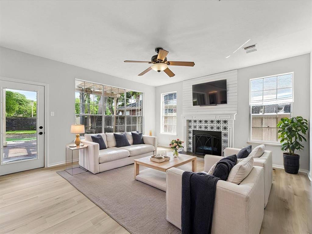 BRIGHT AND INVITING FAMILY ROOM WITH NEW FLOORING, FRESHLY PAINTED WALLS, AND A MODERN TILED FIREPLACE AS THE FOCAL POINT. WITCH ACCESS TO THE BACKYARD. **This room has been virtually staged.