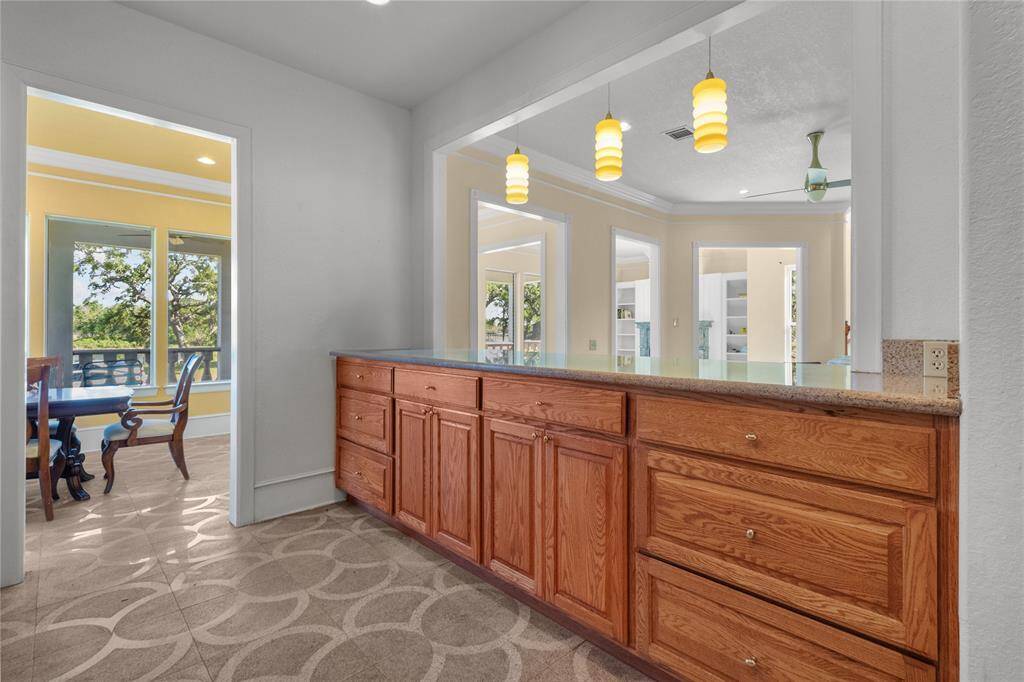 Spacious kitchen featuring elegant wooden cabinetry, sleek stainless steel appliances, and a convenient layout that flows into a bright dining area. Perfect for culinary enthusiasts and entertaining guests.