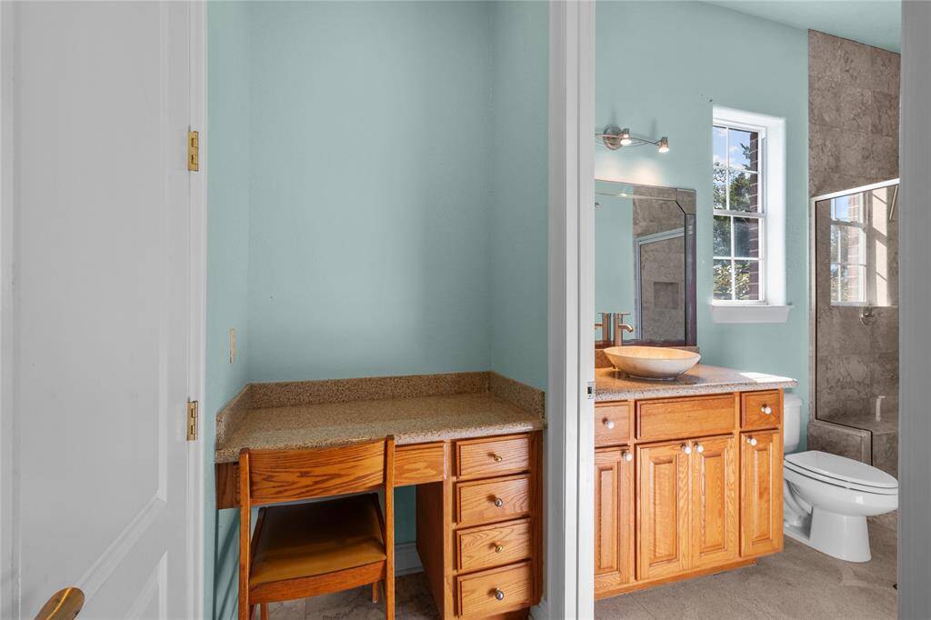 Elegant downstairs bathroom featuring a modern vessel sink, sleek granite countertop, and a spacious glass-enclosed shower.