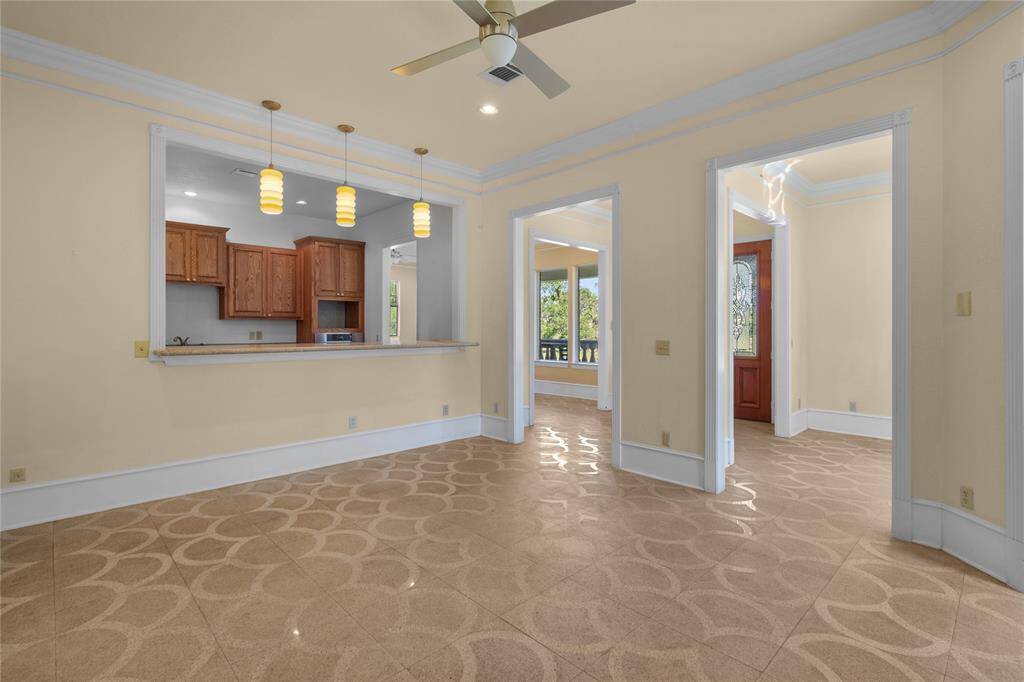 Spacious and inviting downstairs living area featuring elegant tile flooring, abundant natural light, and a cozy fireplace, perfect for relaxation and entertaining.