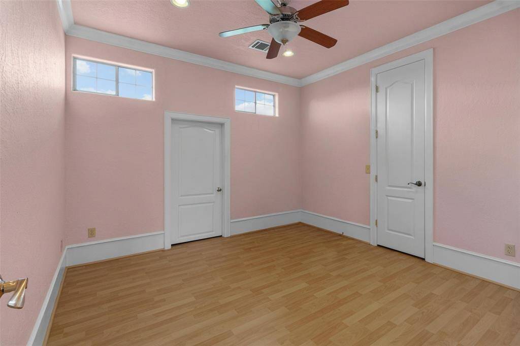 Bright and inviting upstairs bedroom with elegant stained glass doors and ample natural light. Ideal for relaxation or study.