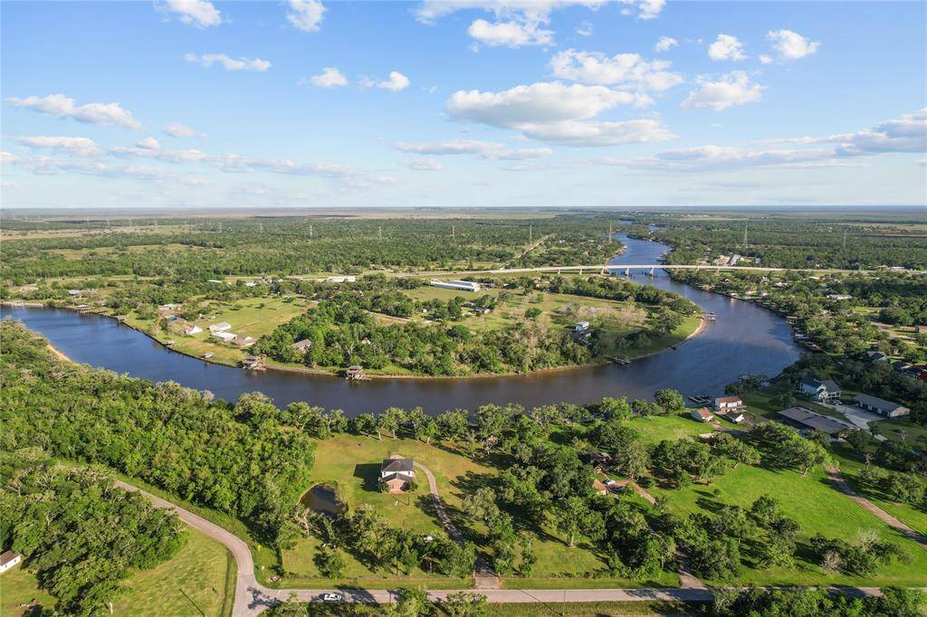 Stunning aerial view showcasing the home's picturesque riverside location, surrounded by lush greenery and serene landscapes.