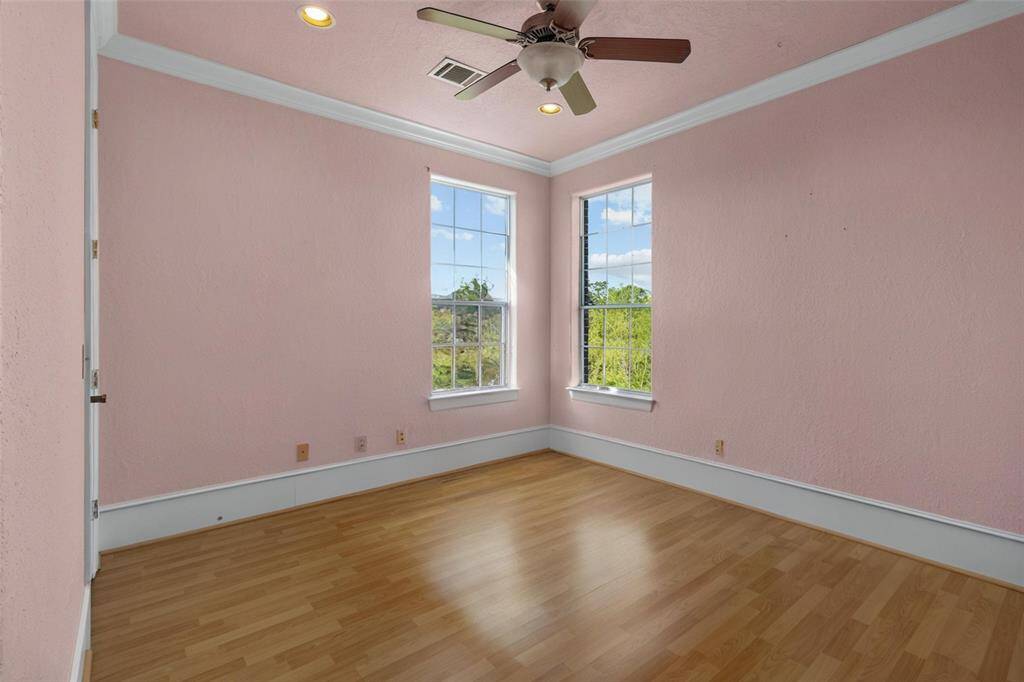 Experience comfort and tranquility in Bedroom 3, featuring abundant natural light, elegant flooring, and charming French door access.