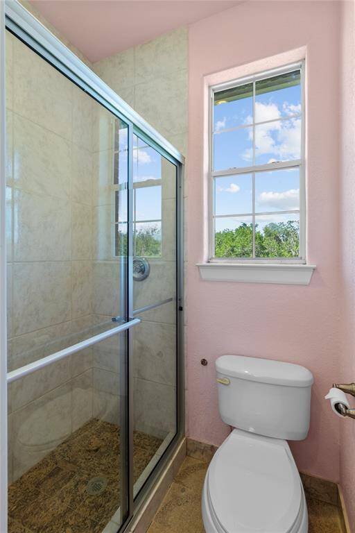 Elegant upstairs bathroom featuring a spacious granite countertop, stylish lighting, and ample storage.