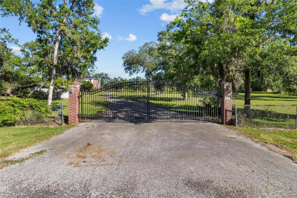 Welcome to your private retreat, featuring a gated entrance and lush greenery, offering both security and serenity.