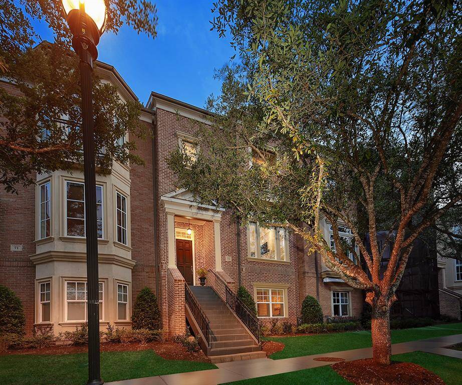 Gorgeous, well-appointed brick exterior has grand entrance to home with brick stairs and iron railing.