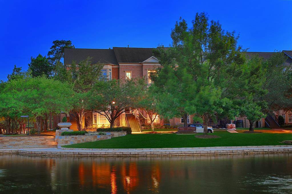 Stunning waterfront home is surrounded by lush greenery and stone architecture throughout the upscale grounds.