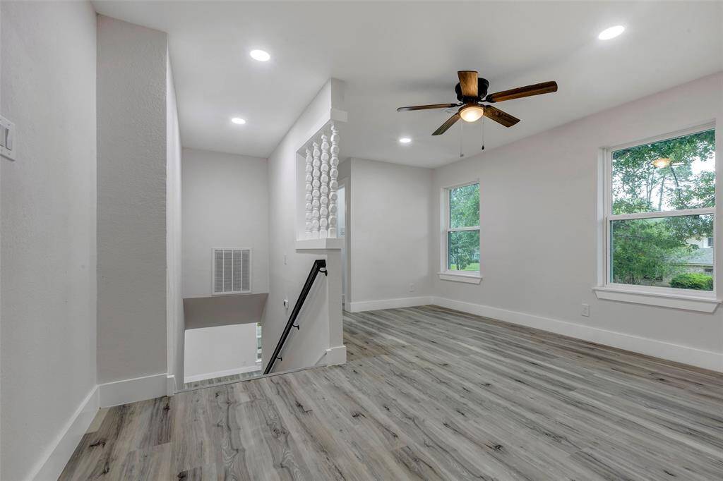Upstairs game room with large window and ceiling fan.