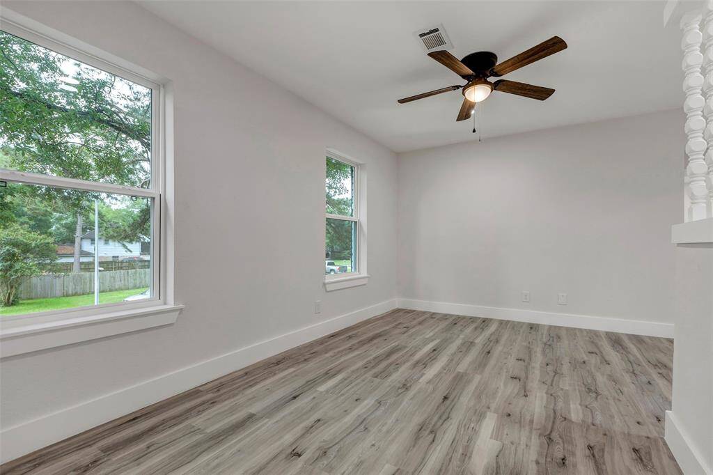Upstairs game room with large window and ceiling fan.