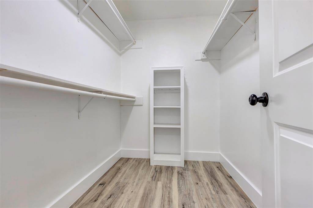 Primary closet with shelves and built ins.