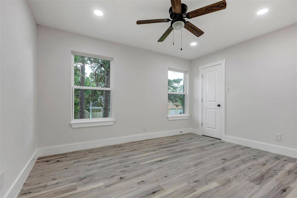 Secondary bedroom #1 with walk in closet, Vinyl flooring, ceiling fan and recess light.