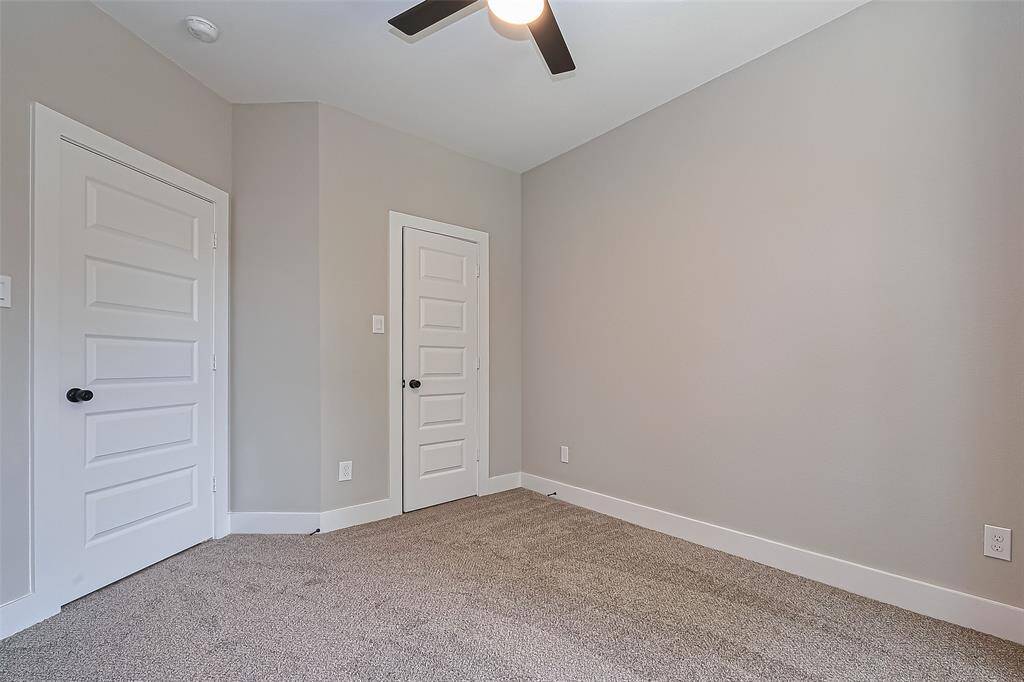Versatile Bedroom with Clean, Modern LinesWith dual closet doors, fresh paint, and plush carpet underfoot, this secondary bedroom offers both comfort and utility. The sleek ceiling fan and matte black hardware tie into the home’s modern design while offering a blank canvas for personalization—ideal for guests, kids, or workspace needs.