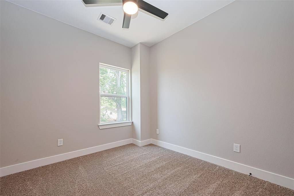 Bright & Comfortable Third BedroomSoaked in natural light, this third bedroom offers peaceful views, neutral tones, and cozy carpeting underfoot. A sleek ceiling fan ensures comfort year-round, making it a perfect fit for a secondary bedroom, creative studio, or a peaceful work-from-home space.