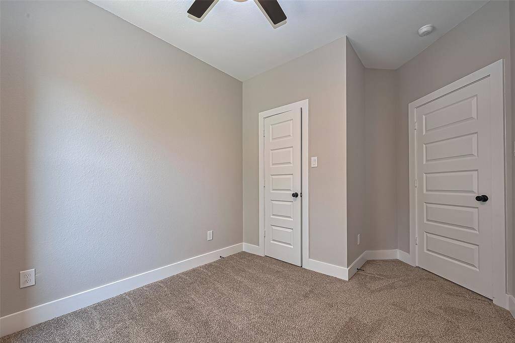 Well-Appointed Bedroom with Ample StorageDesigned with functionality in mind, this secondary bedroom features two spacious closets and clean architectural lines. Neutral tones, plush carpet, and a modern ceiling fan make this room move-in ready and easy to personalize—perfect for guests, teens, or a dedicated workspace.